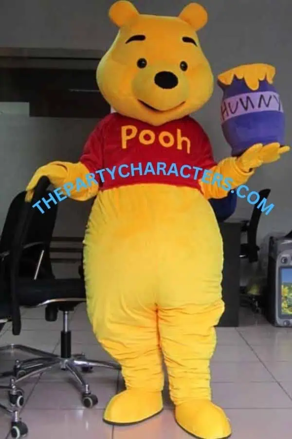 Costumed Winnie the Pooh character standing indoors in a red Pooh shirt, yellow fur, and a purple honey pot labeled 'HUNNY' in one hand. Watermark across the midsection reads 'THEPARTYCHARACTERS.COM'.